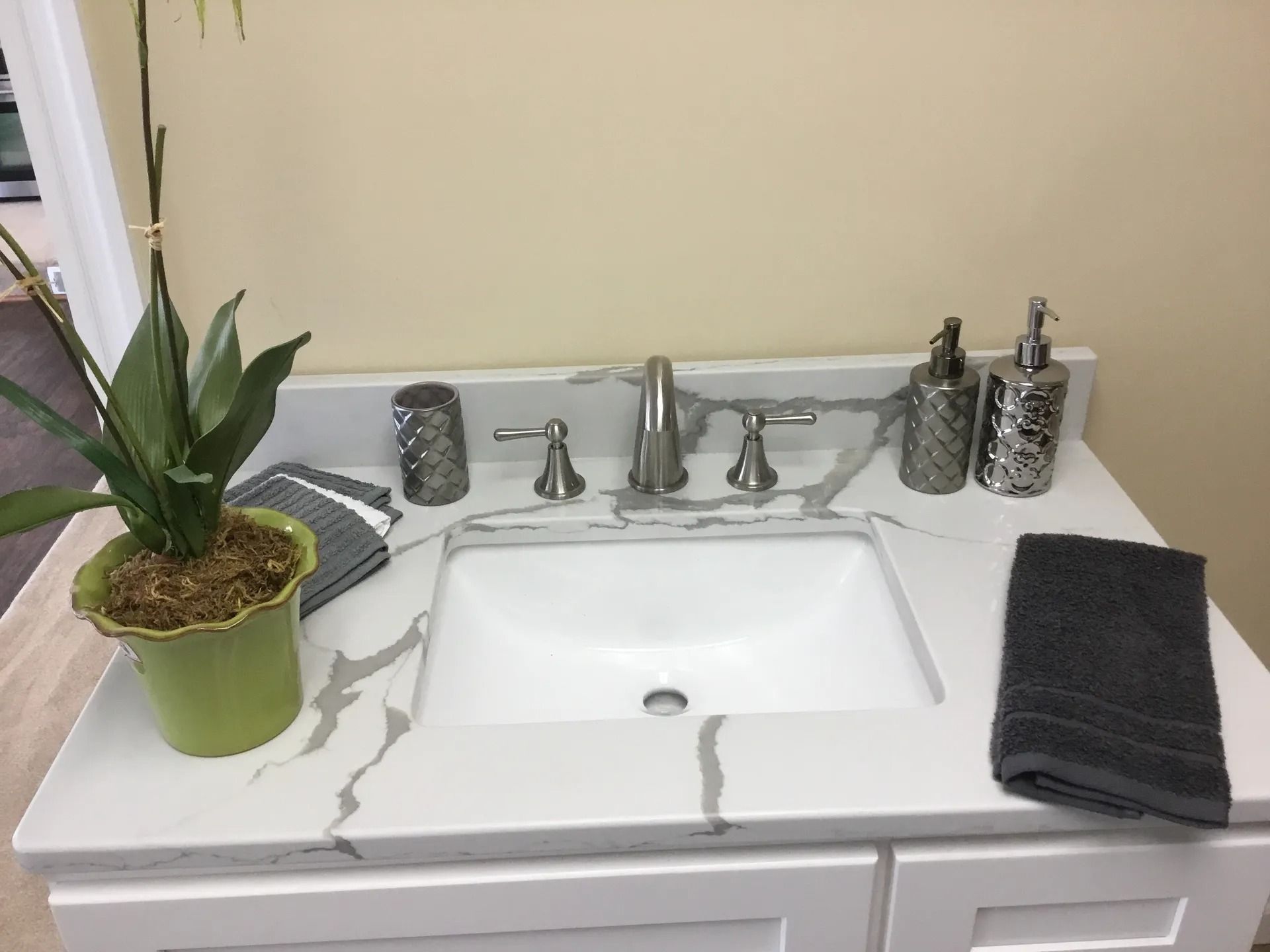 A bathroom sink with a potted plant on top of it