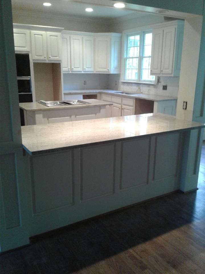 A kitchen with white cabinets and granite counter tops