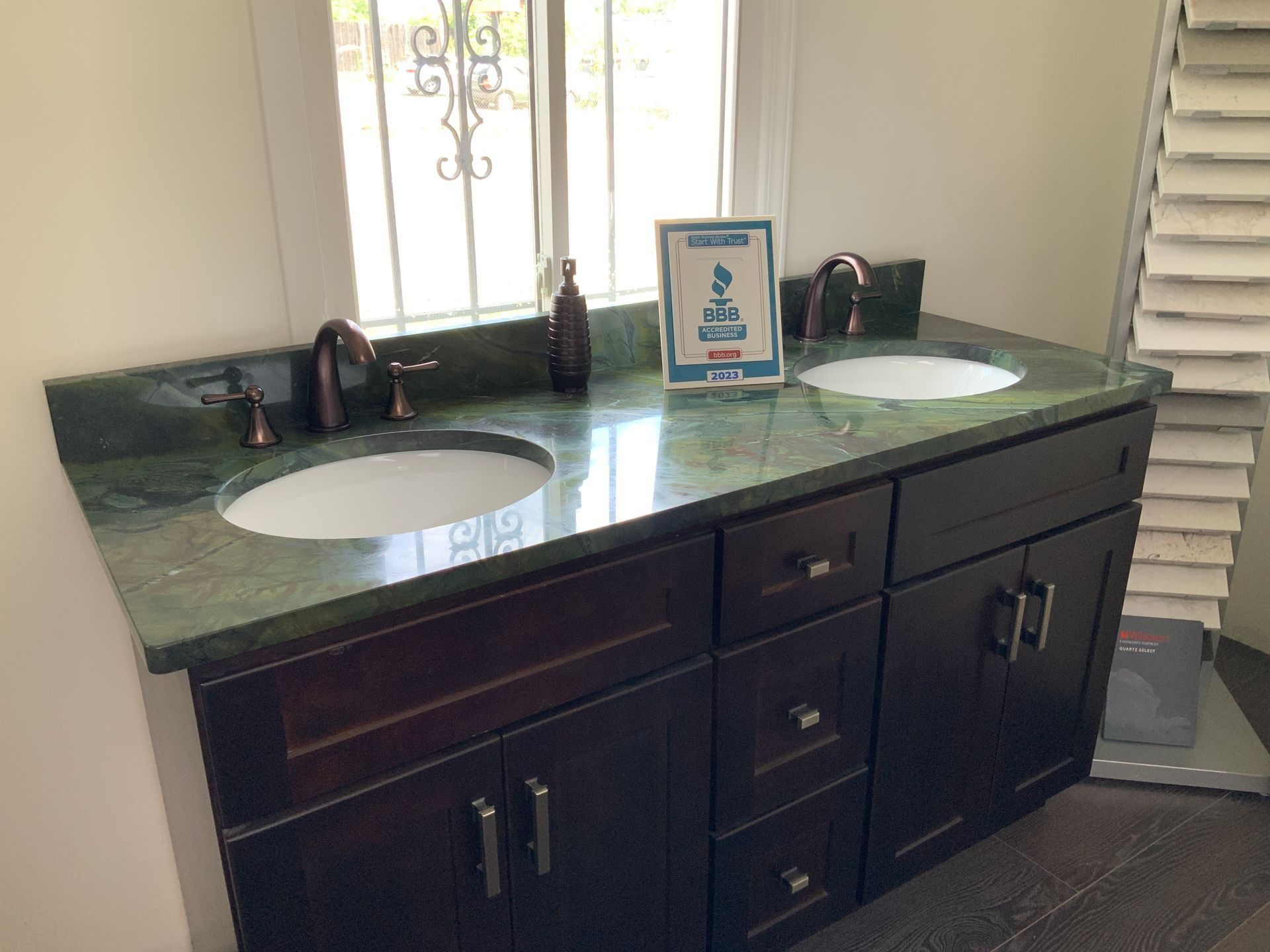 A bathroom with two sinks and a green counter top