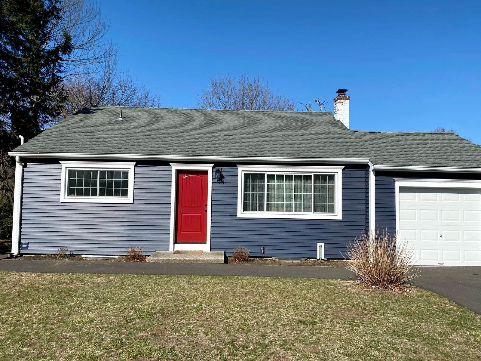 A blue house with a new roof and siding