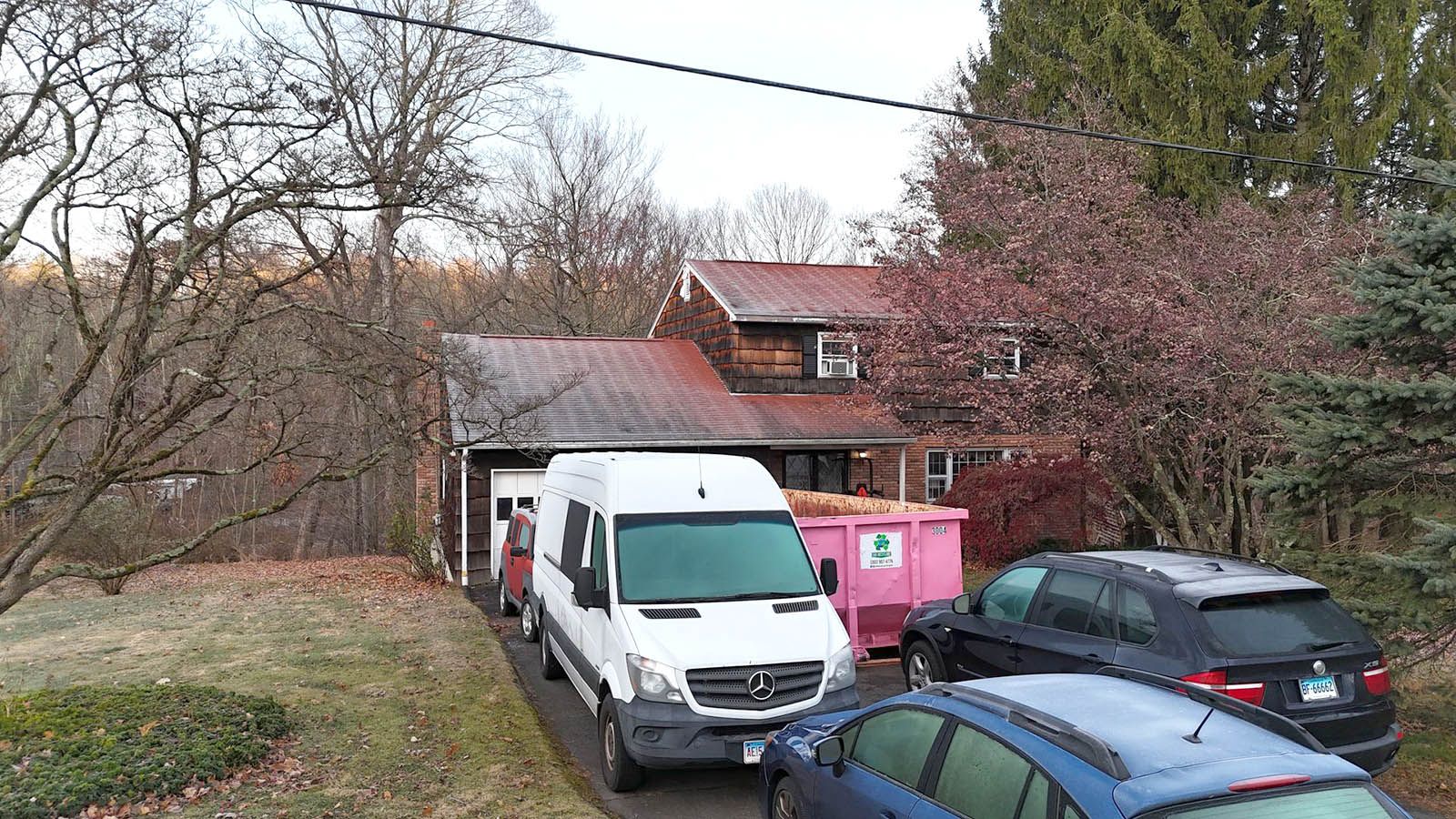 An old house with cars parked in front of it