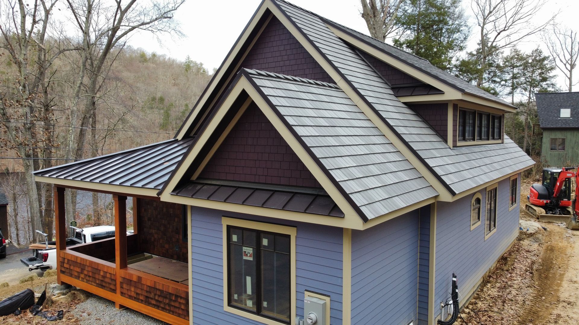 A small house with a slate roof is being built in the woods.