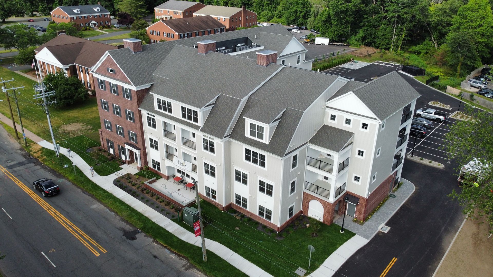 An aerial view of a large apartment building next to a road.