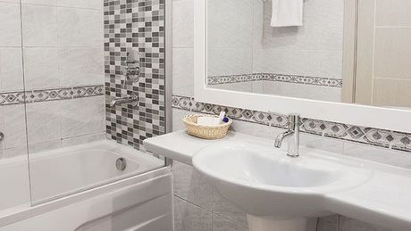 A bathroom with a sink , bathtub and mirror.