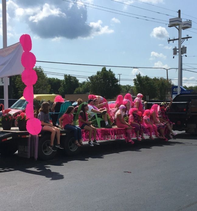 A group of people are sitting on the back of a truck in a parade