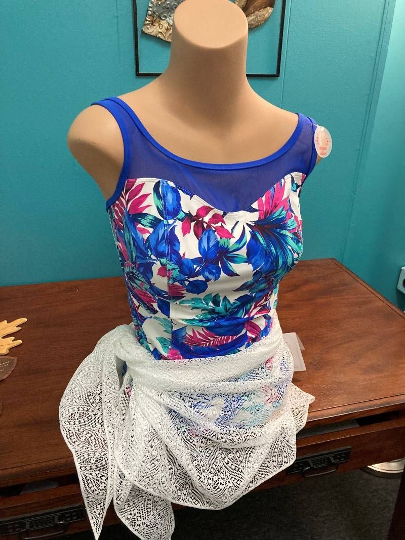 A mannequin is wearing a blue and white floral top and a white lace skirt.