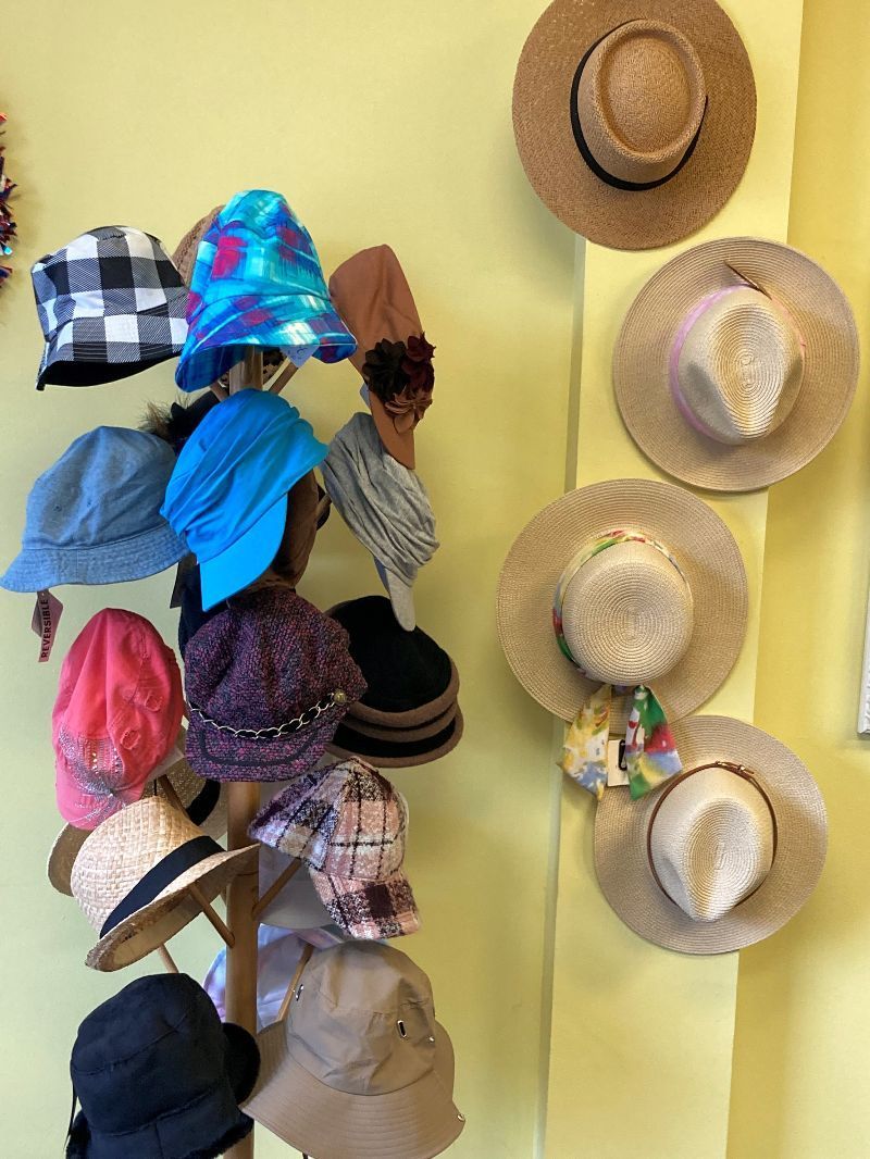 A bunch of hats are hanging on a wall