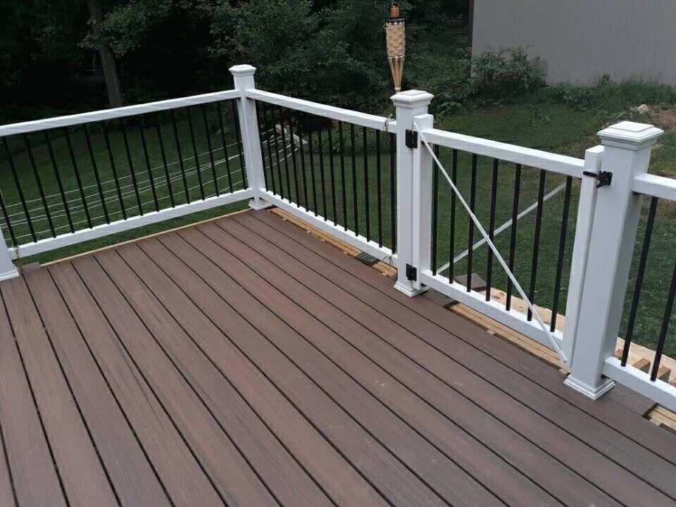Brown composite deck with white railings and black spindles, viewed from above.
