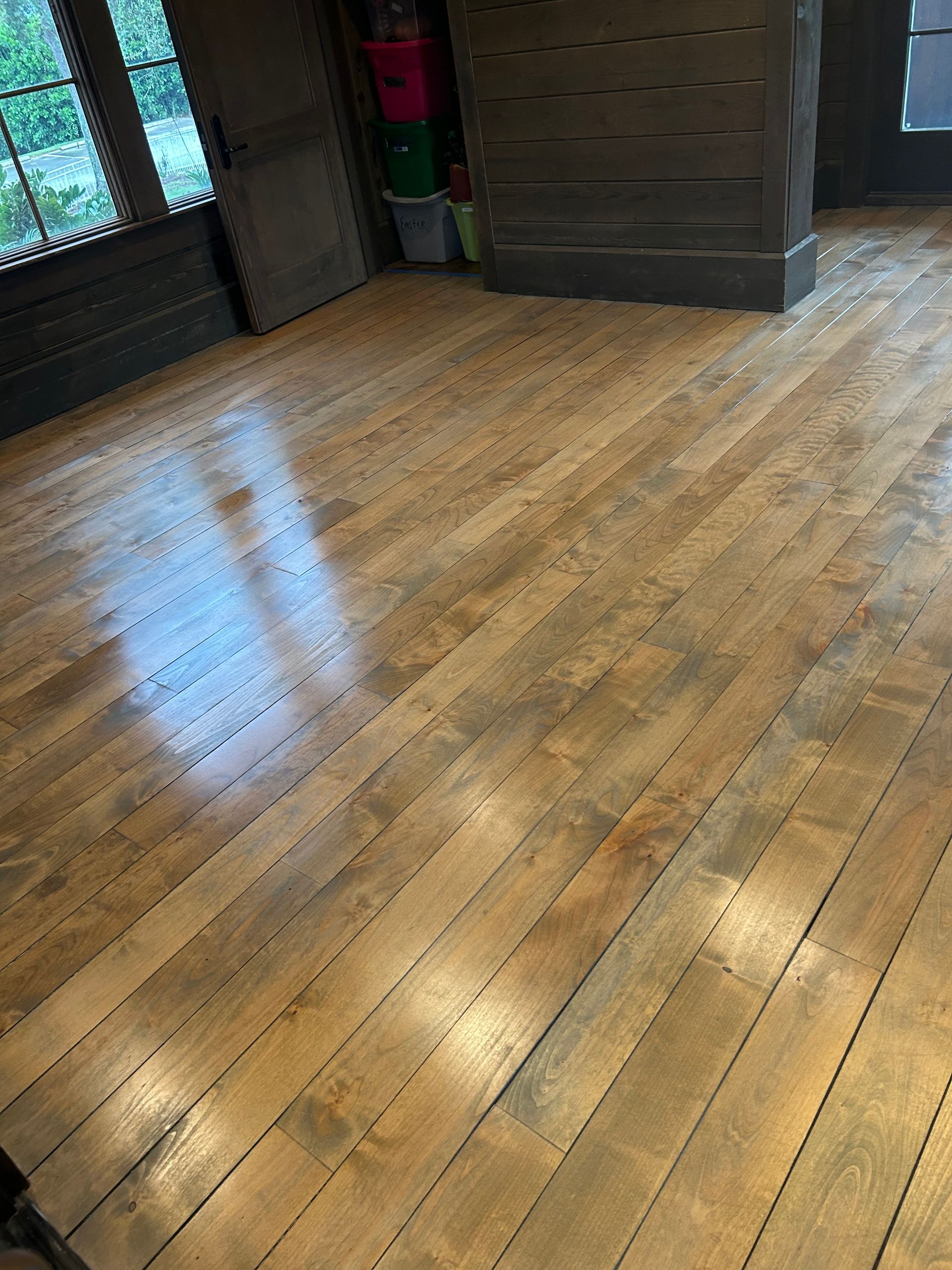 A room with a wooden floor and a window.