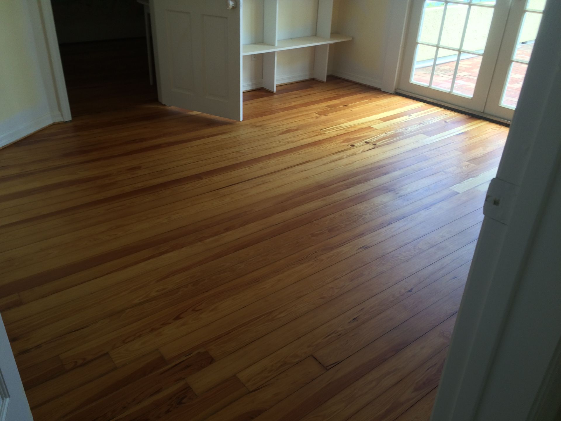 A room with a wooden floor and a bookshelf
