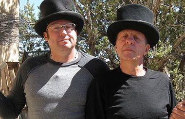 Two men wearing top hats are standing next to each other
