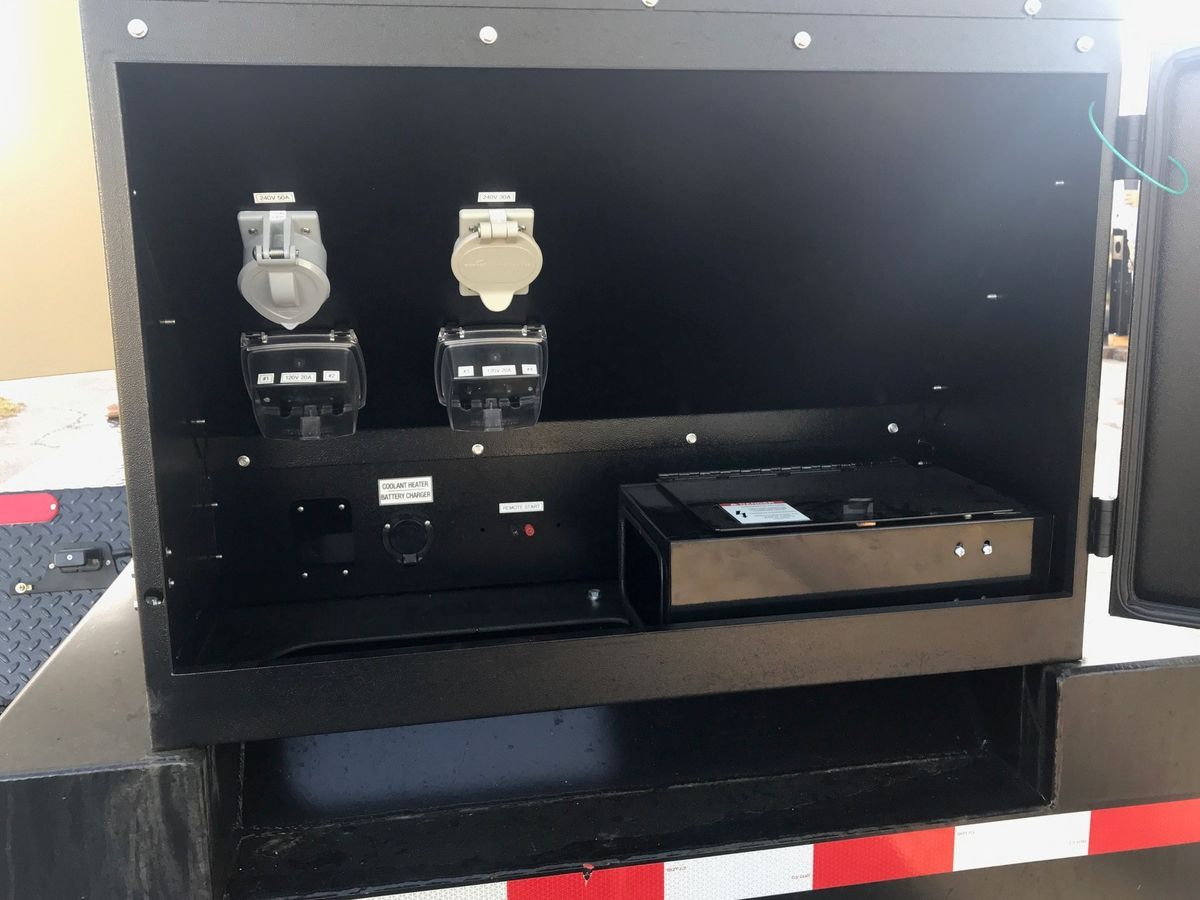 Open cabinet with two metal valves on top and a black device inside, seen against a dark background