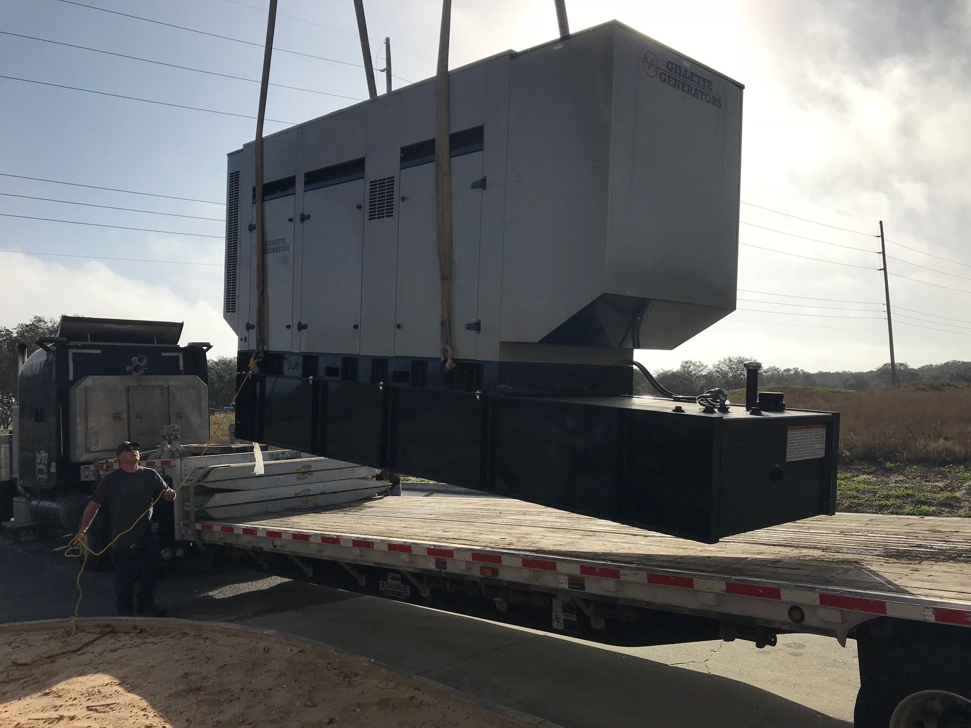 Large gray industrial machine on a flatbed trailer in an open field
