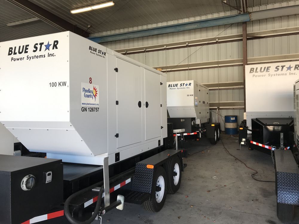 Blue Star industrial generators lined up inside a warehouse, white units on trailers with one showing 100 kVA