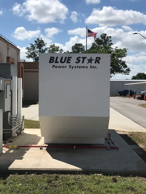 Blue Star Power Systems sign on a white utility unit outside, with an American flag above it.