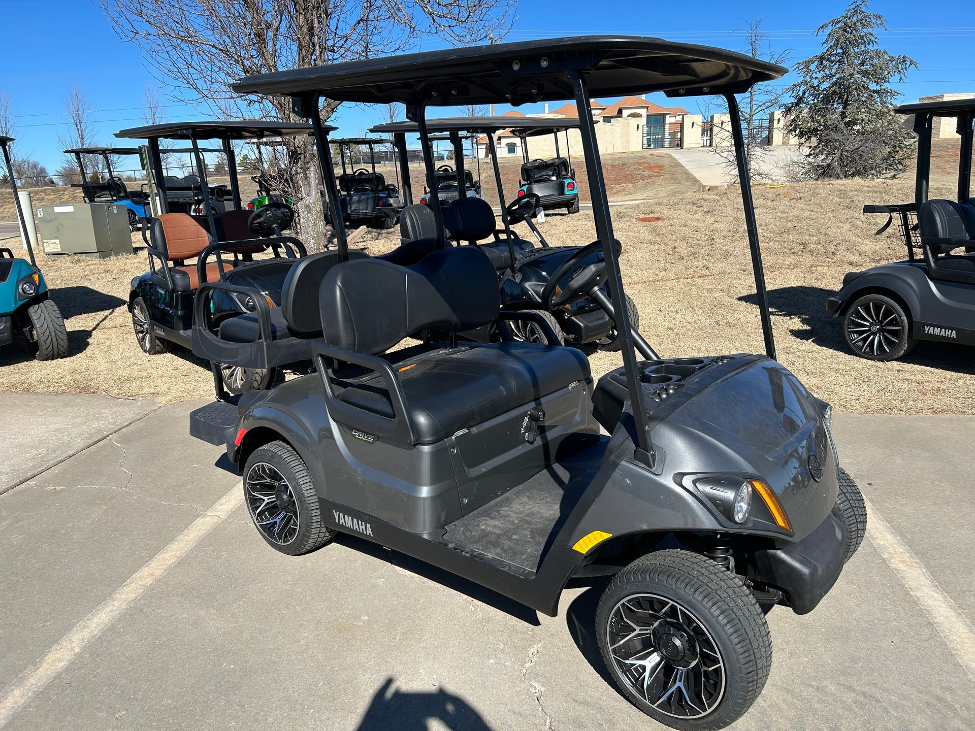 A gray golf cart is parked in a parking lot