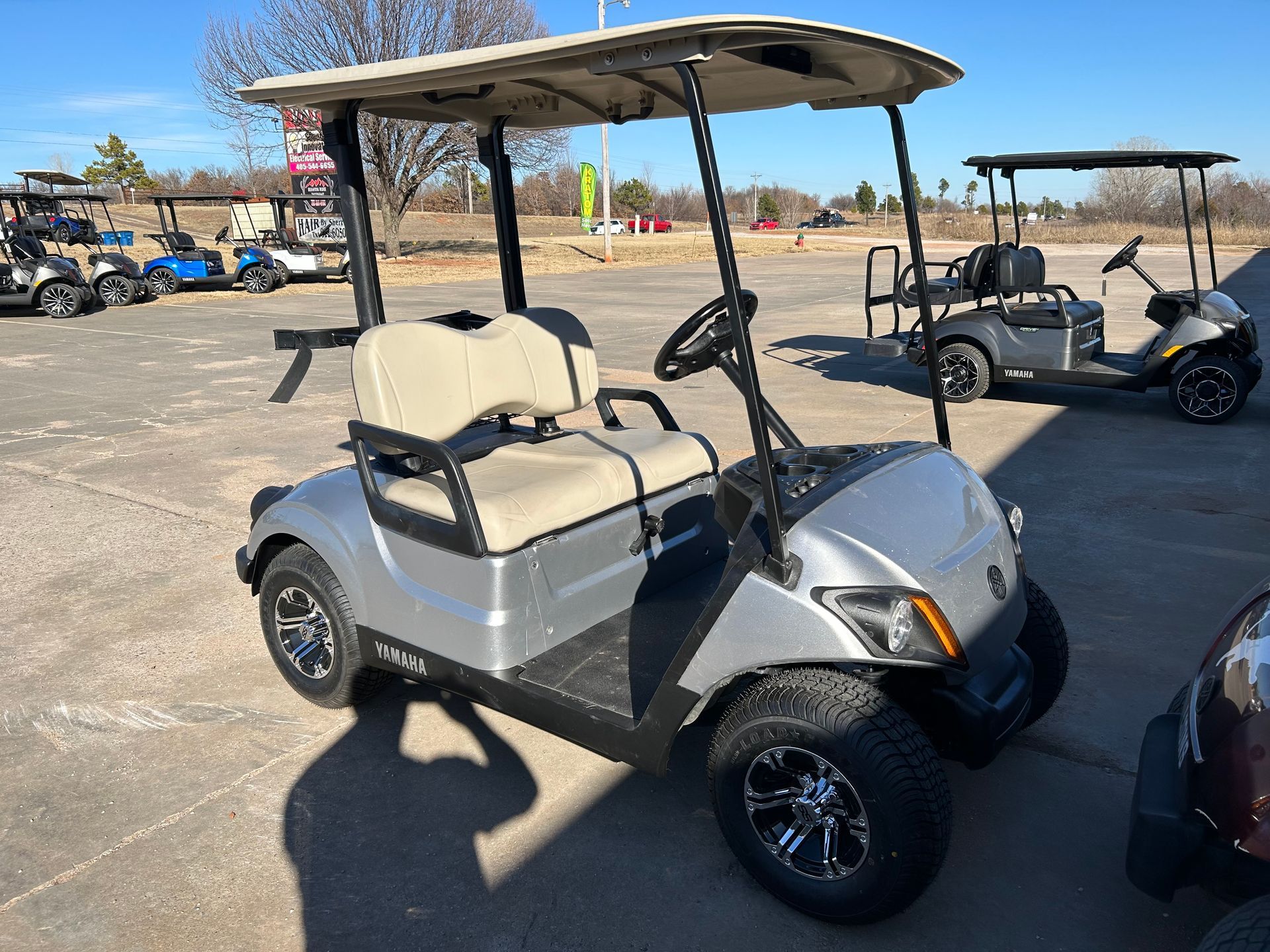 A silver golf cart is parked in a parking lot