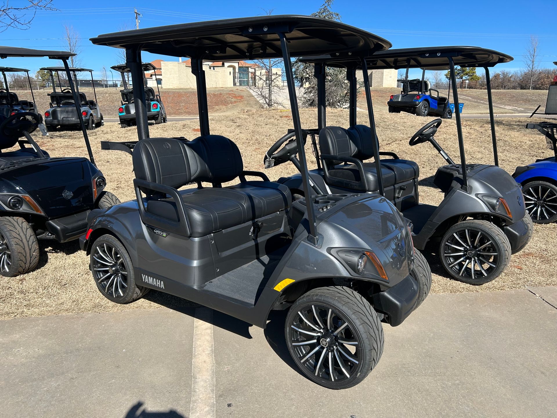 A row of golf carts are parked in a parking lot
