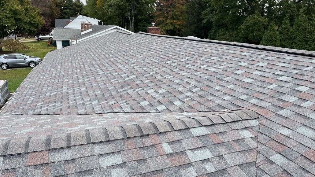 A close-up view of a multi-colored shingled roof on a house.