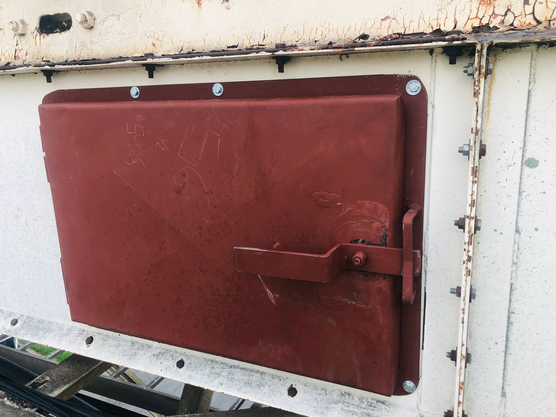 A red door is sitting on a white wall