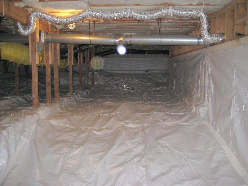 Plastic-lined crawlspace beneath a house with exposed pipes, joists, and insulation glow light.