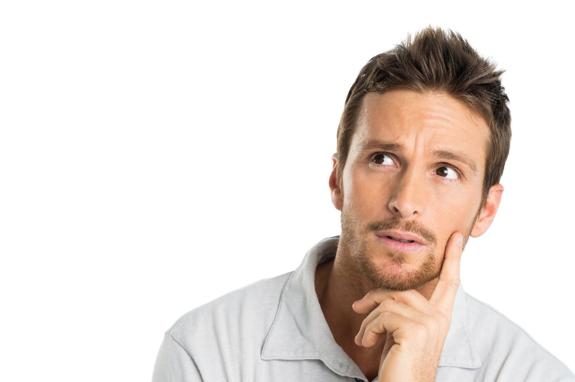Thoughtful man in a light gray shirt looking up and touching his chin against a white background
