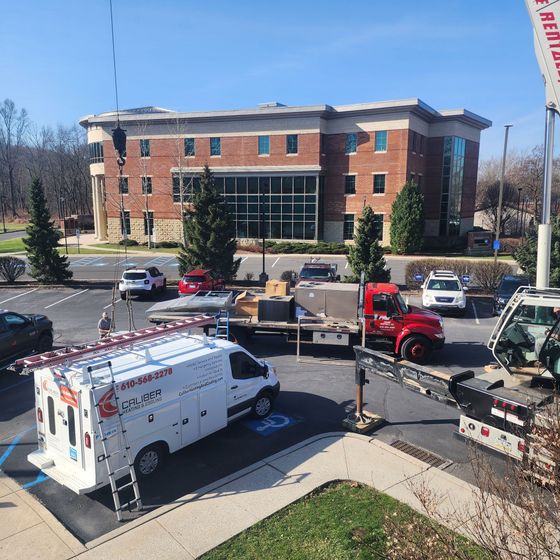 A white van is parked in front of a large brick building