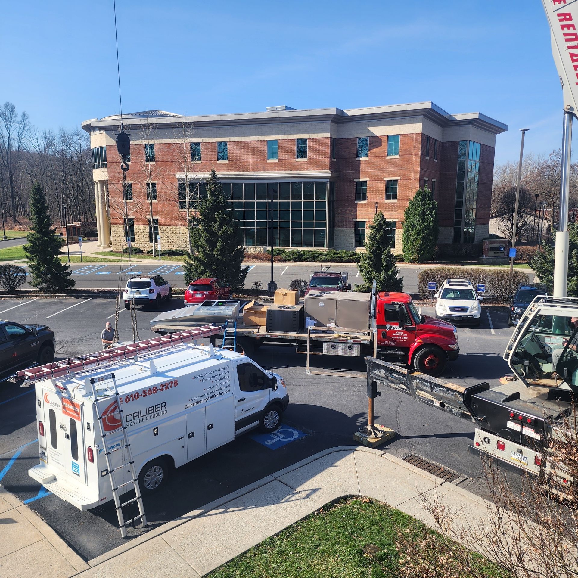 A white van is parked in front of a large brick building