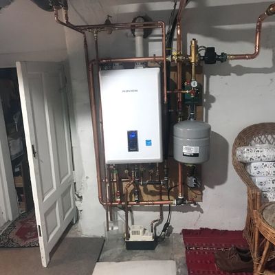 A room with a water heater and copper pipes