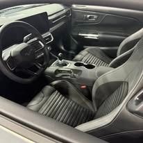 Black car interior: steering wheel, dashboard, seats.