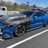 Blue and black sports car on asphalt.
