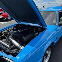 Blue car with hood open, showing engine.