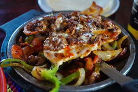 A close up of a plate of food with meat and vegetables on a table