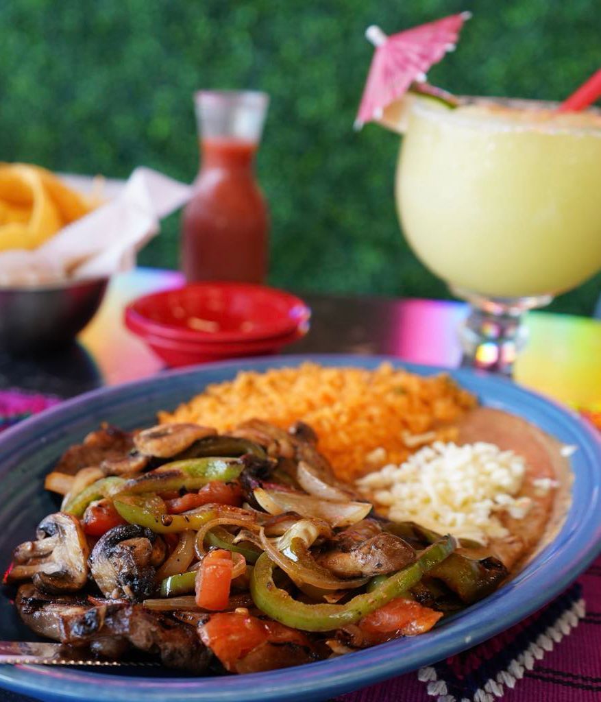 A plate of food with rice and a drink on a table