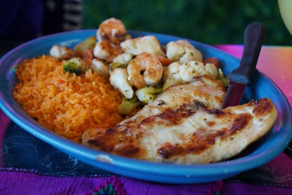 A plate of food with shrimp and rice on a table.