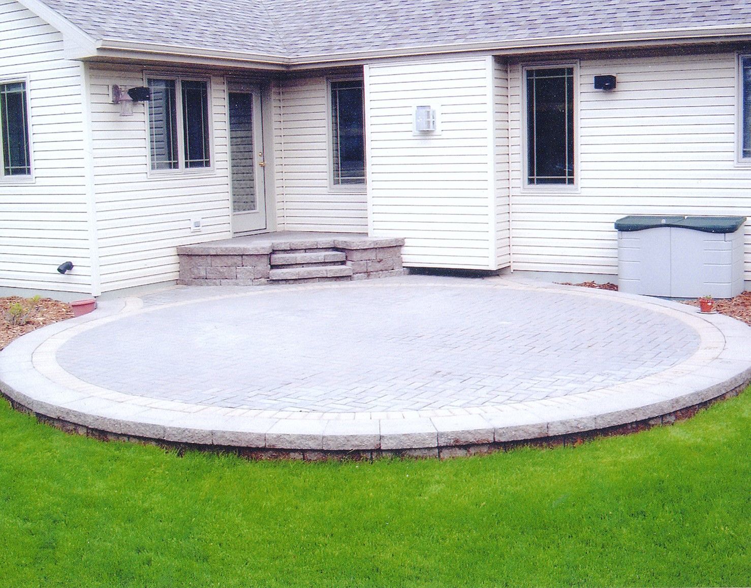 A white house with a circular patio in front of it