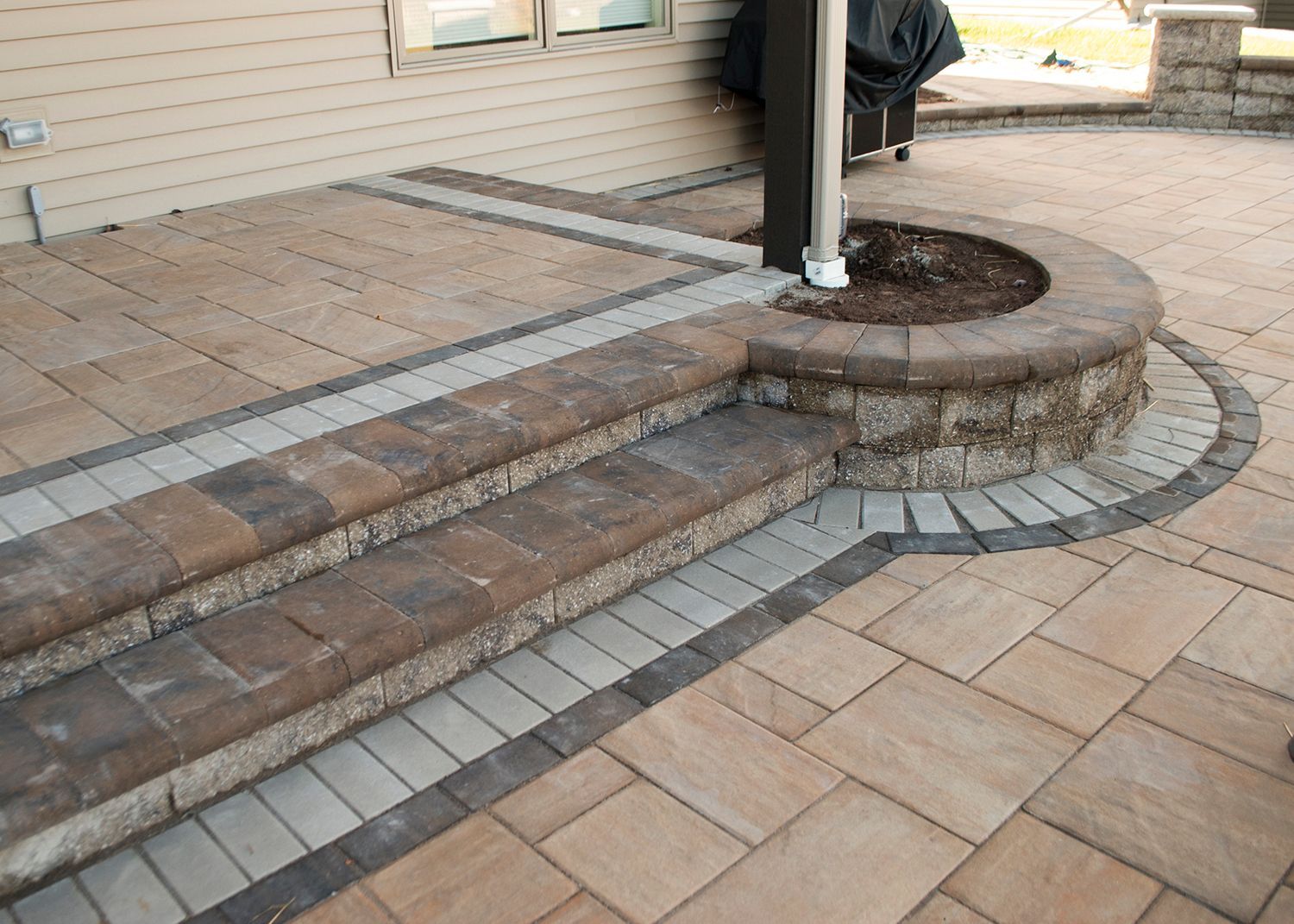A patio with steps and a planter in the middle
