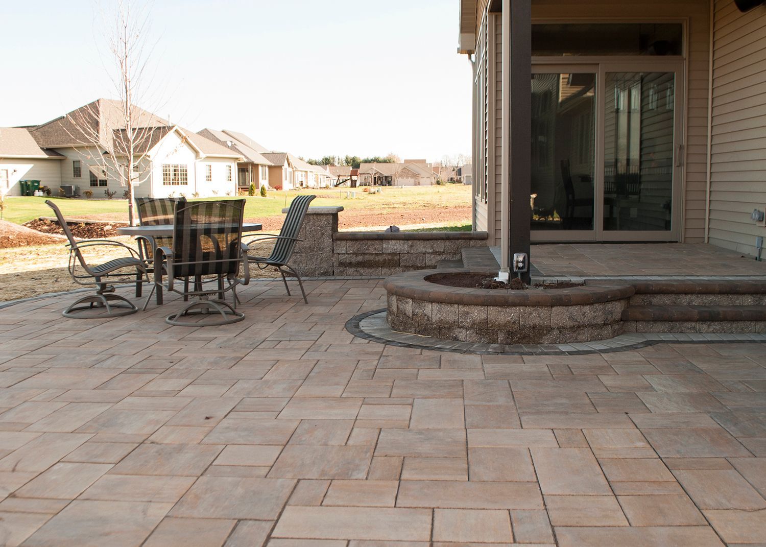 A patio with a table and chairs in front of a house