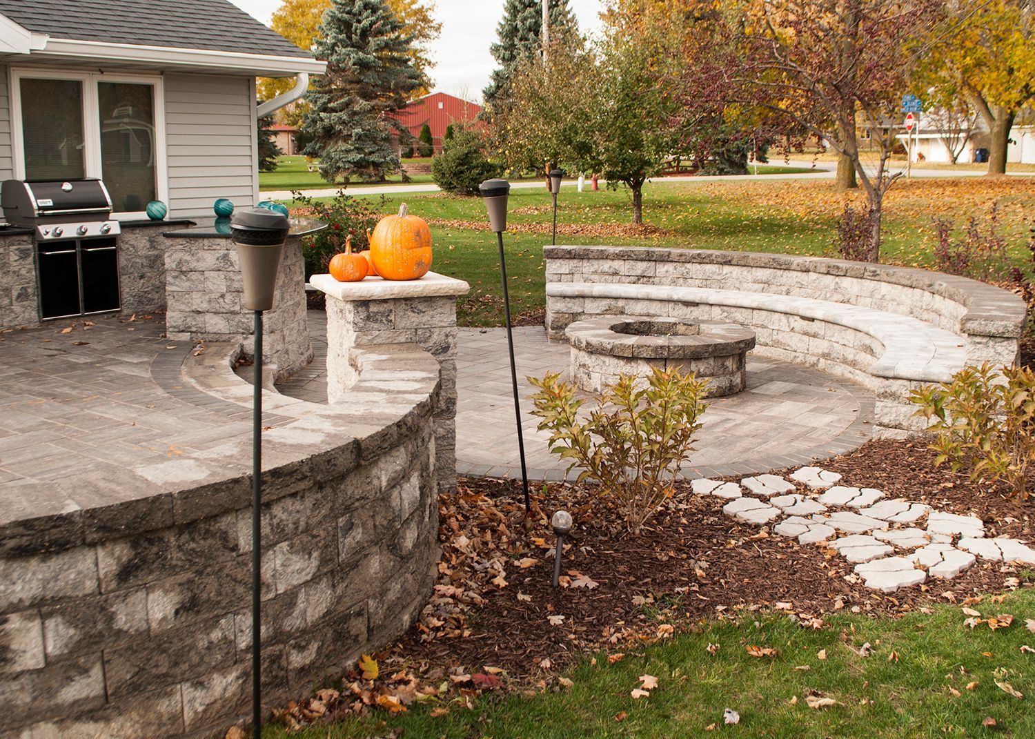 There is a fire pit in the backyard of a house.