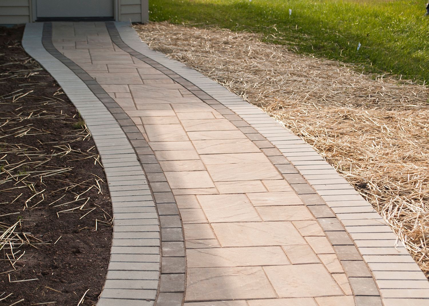 A brick walkway leading to a garage door