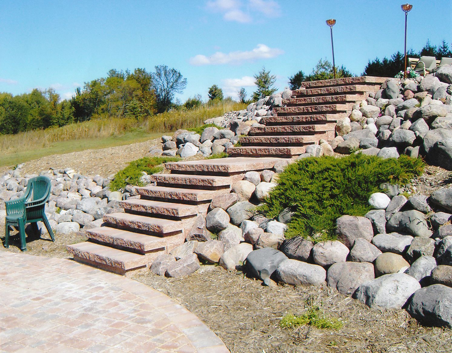 A green chair sits next to a set of stone stairs