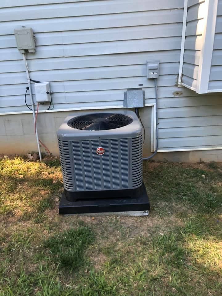 An air conditioner is sitting on the side of a house.