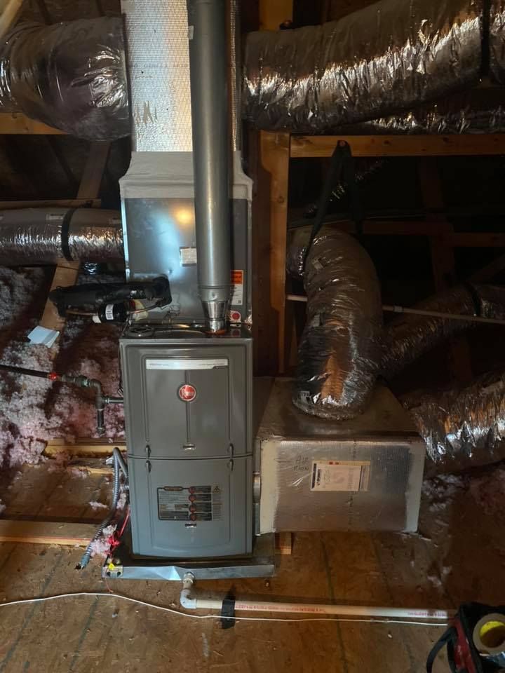 A furnace is sitting in the attic of a house.