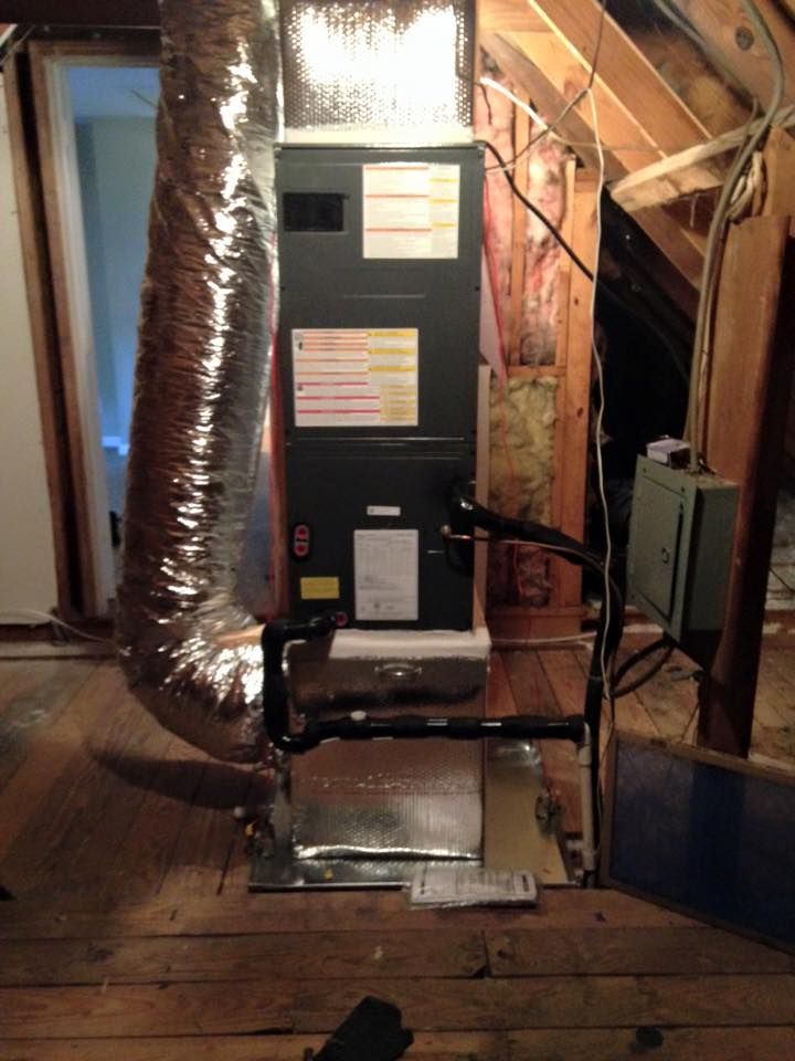 An air conditioner is sitting in the attic of a house.