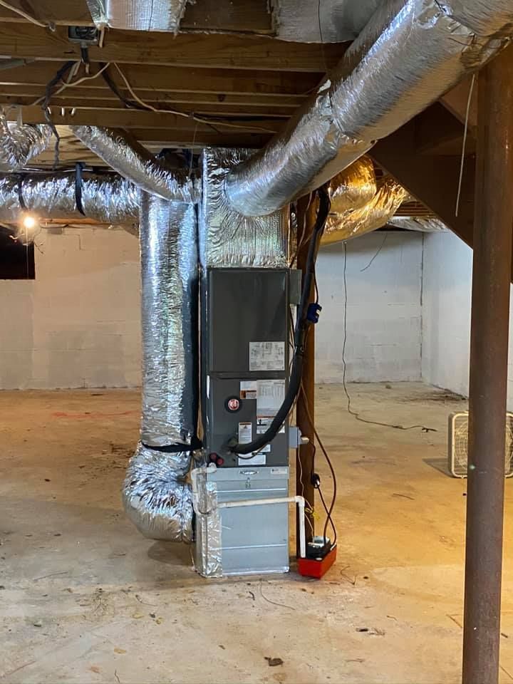 A basement with a heating and air conditioning system in it.