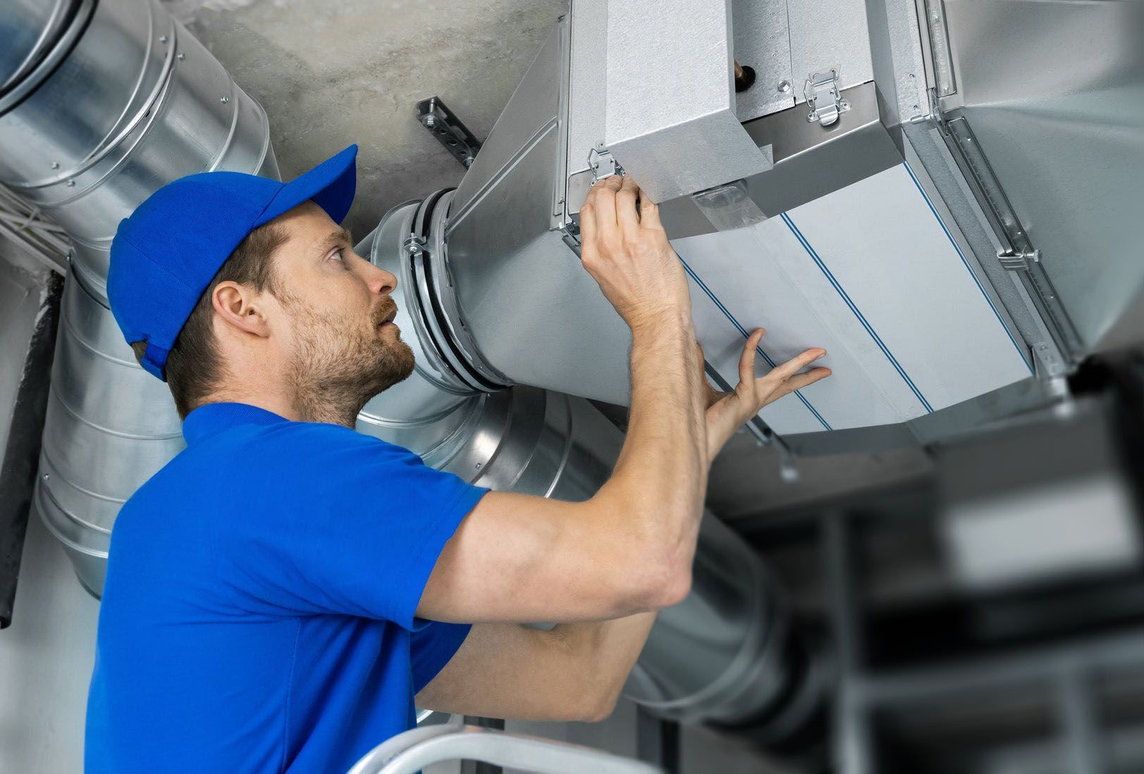a man is working on a ventilation system in a building
