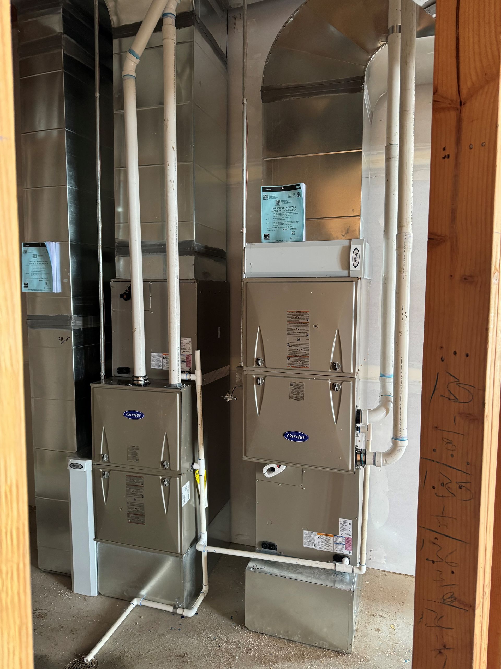 Two air conditioners are sitting next to each other in a room.