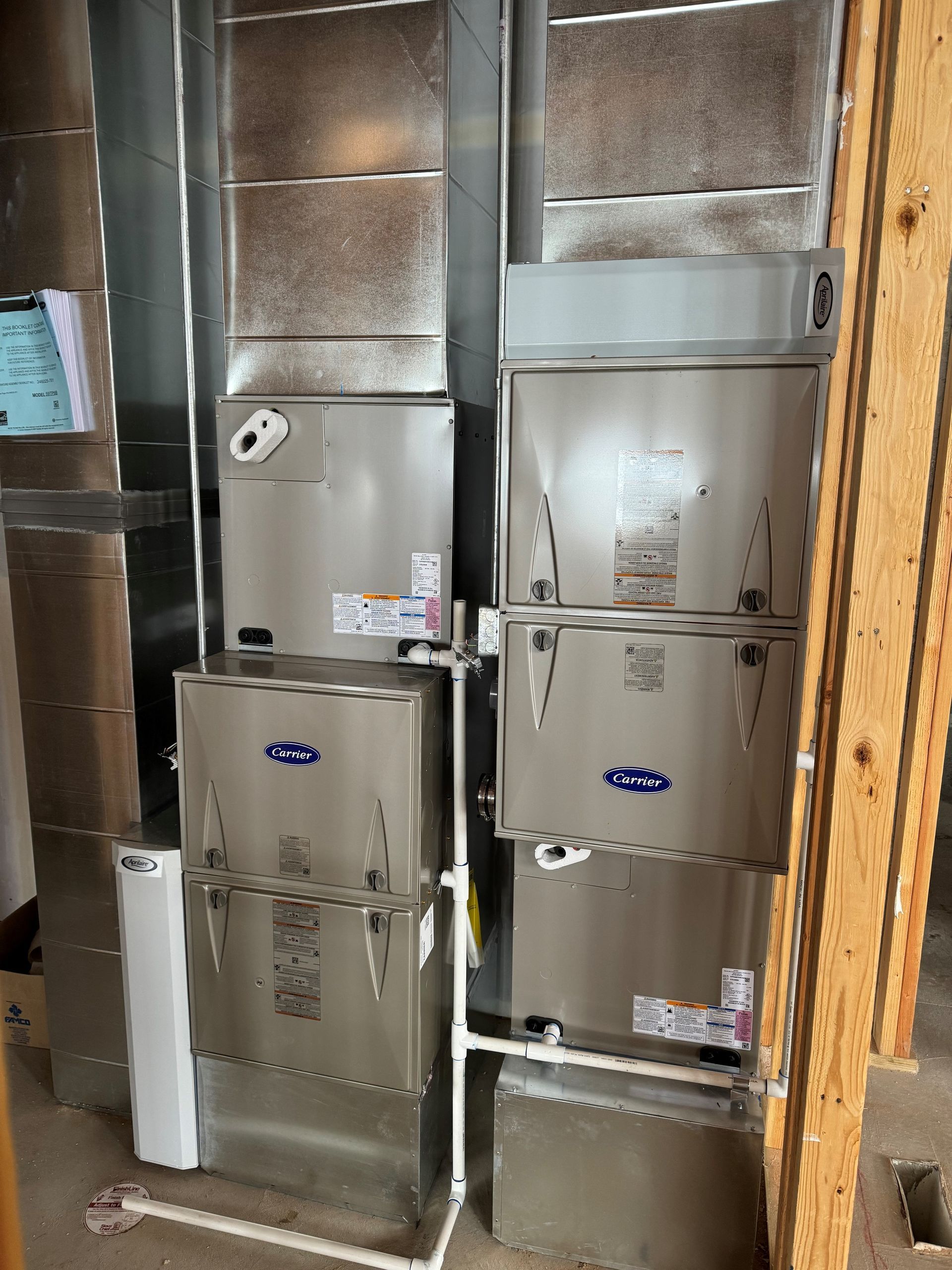 Two air conditioners are stacked on top of each other in a room.