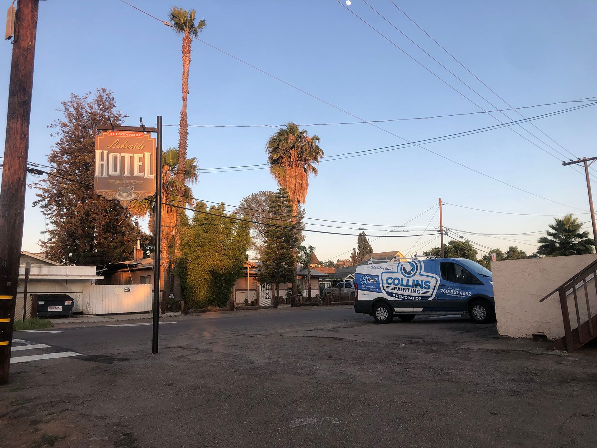 A blue van is parked in front of a hotel sign