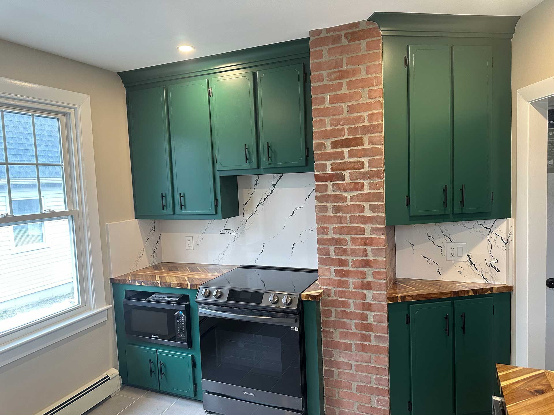 a kitchen with green cabinets and an oven